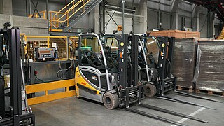 DHL Aviation Brüksel tesisinde merkezi olmayan şarj istasyonunda operasyona hazır bekleyen STILL RX 20 lityum-iyon elektrikli forkliftler.